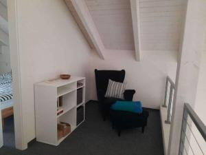 a living room with a chair and a book shelf at Holiday home Neukalen Comfortable holiday residence in Neukalen