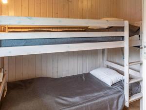 Huus Naturstrand am Diek في Wesselburen: غرفة بسريرين بطابقين في كابينة