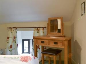 a bedroom with a dresser with a mirror and a bed at Ivy Cottage in Elton