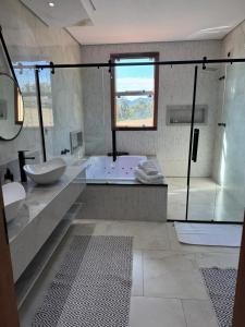 a bathroom with a tub and a sink and a shower at Hotel Boutique Canto da Seriema in Tiradentes