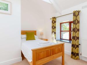 a bedroom with a bed and a desk and a window at 3 Bed in Praa Sands 36257 in Germoe