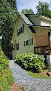 a yellow house with flowers in front of it at Mallard Cove - lakeside pet friendly in Robbinsville