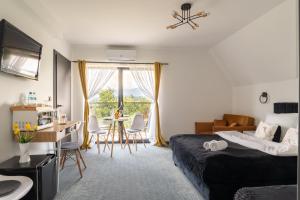 a hotel room with a bed and a table and chairs at Siedmiu Króli Rooms&SPA in Bukowina Tatrzańska