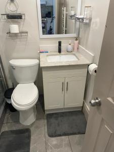 a bathroom with a white toilet and a sink at Queen Street AC SUITE-Free Wifi& Self Checkin in Toronto