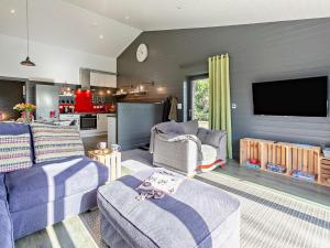 a living room with purple furniture and a flat screen tv at 3 Bed in Penzance 1.5 mls 75635 in Gulval