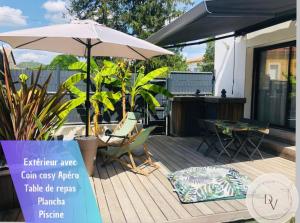 eine Terrasse mit einem Sonnenschirm, Stühlen und einem Tisch in der Unterkunft La Dolce Villa - Bali&les Cévennes in Alès