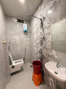 a bathroom with a sink and a toilet and a mirror at Hotel Tathaastu Palace in Ujjain