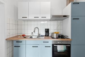 a kitchen with white cabinets and a sink at Business Apartment Alte Post in Unterlüß