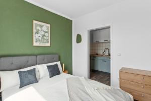 a bedroom with a green accent wall and a bed at Business Apartment Alte Post in Unterlüß