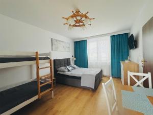 a bedroom with two beds and a chandelier at Złote Piaski Pensjonat z basenem in Darłowo +53 photos