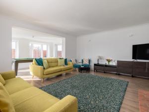 a living room with two yellow couches and a flat screen tv at 4 Bed in West Runton 81469 in West Runton