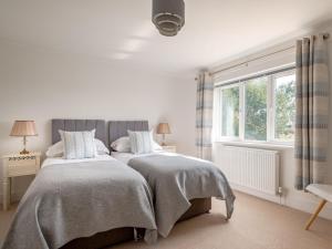 a bedroom with two beds and a window at 4 Bed in West Runton 81469 in West Runton