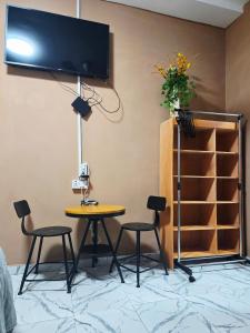a table and chairs in a room with a tv on the wall at Niji Luxury studio apartments in Amasaman +59 photos