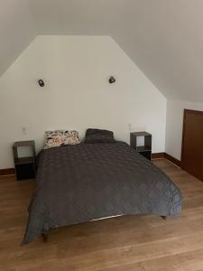 a bed in a bedroom with two night stands at Maison en campagne avec chambre mezzanine in Priziac