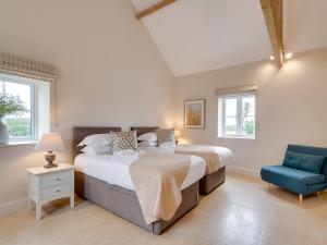 Finghallにある4 Bed in Bedale 80704のベッドルーム1室(ベッド2台、青い椅子付)