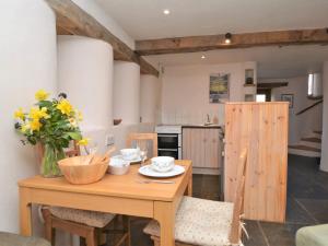 a kitchen with a wooden table with flowers on it at 1 Bed in Charmouth CIBAR in Whitchurch Canonicorum