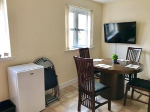 ein Zimmer mit Tisch und Stühlen und einem Fernseher in der Unterkunft Woodgrove Holiday Homes in Inshes