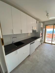 a kitchen with white cabinets and a large window at Luxury Vintage Rooftop Appartment in Antibes +13 photos