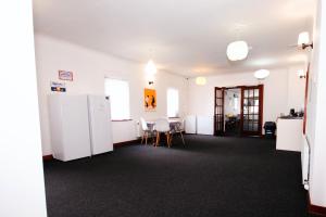 a room with white appliances and a table and chairs at Weston House Keith in Keith