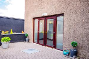 a patio with sliding glass doors and potted plants at Weston House Keith in Keith