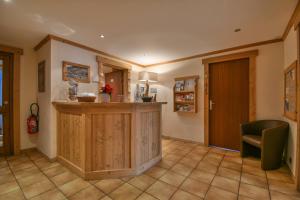 a kitchen with a counter and a green chair at Hotel les Flocons in Le Grand-Bornand