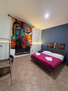 a bedroom with a bed with a painting on the wall at Dalle ziette! in Civitavecchia +82 photos