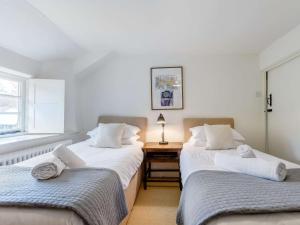 two twin beds in a room with a table at 2 Bed in Dulverton 47152 in East Anstey