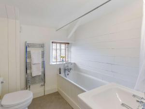 a white bathroom with a tub and a toilet at 2 Bed in Dulverton 47152 in East Anstey +13 photos