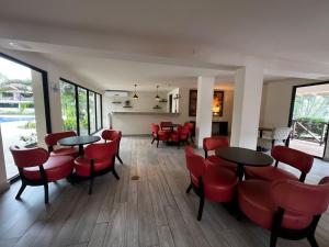 una sala da pranzo con sedie e tavoli rossi di Relaxing Suite Coronado, Panamá a Chame