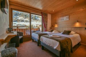 a hotel room with two beds and a balcony at Hotel les Flocons in Le Grand-Bornand +107 photos