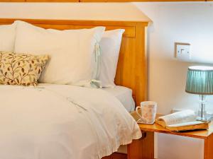 a bedroom with a bed and a table with a lamp and a book at 1 Bed in Kidwelly 43406 in Kidwelly