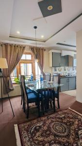 a dining room with a table and chairs and a kitchen at Soma Hotels Skardu in Skardu