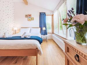 a bedroom with a bed and a vase of flowers at 3 Bed in Freshwater East 66265 in Stackpole Elidor