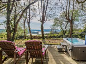 two chairs and a hot tub on a patio at 1 Bed in Yelverton 88860 in Bere Alston