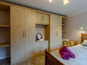 a bedroom with a bed with white cabinets and purple towels at 1 Bed in Fordingbridge 89512 in Fordingbridge