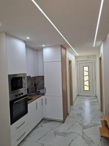 Una cocina con gabinetes blancos y un horno de estufa. en Oaza mira 2, en Jajce 11 fotos más