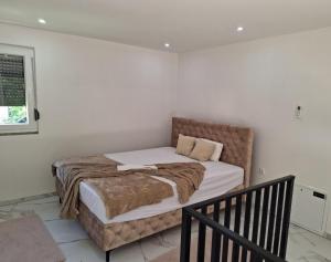a bedroom with a large bed with white walls at Oaza mira 2 in Jajce