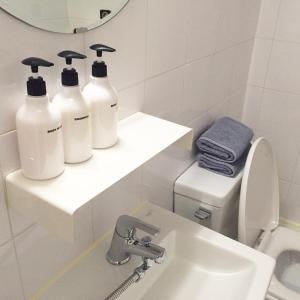 La salle de bains est pourvue de 3 bouteilles de savon et d'un lavabo. dans l'établissement Hostel Beige 2nd, à Séoul
