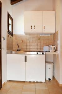a kitchen with white cabinets and a sink at Villa Anna Maria in Agia Paraskevi