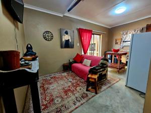 a living room with a red couch and a tv at Nawi Accommodation in Potchefstroom