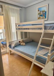 un orsacchiotto seduto sopra un letto a castello di Viñas a Torrevieja