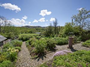 un jardin avec des fleurs et une horloge au milieu dans l'établissement 5 Bed in Eskdale SZ259, à Eskdale