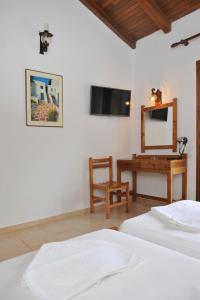 a bedroom with two beds and a desk with a mirror at Villa Anna Maria in Agia Paraskevi