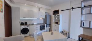 a kitchen with white cabinets and a table and a washer at a PICCIRIDDA in Taormina