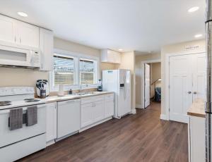 a kitchen with white appliances and wooden floors at Diana's Place - 6 BDR Ranch Long or Short Stays in Murfreesboro