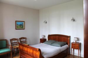 a bedroom with a wooden bed and two chairs at Le château de Mesnil 1916 in Mesnil-Martinsart