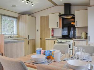 a kitchen with a wooden table with plates and bowls on it at Graylings Rest - Uk35759 in Brigham
