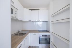 een witte keuken met witte kasten en een spoelbak bij Appartement Les Marines de Sausset in Sausset-les-Pins