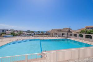 een groot zwembad met een hek eromheen bij Appartement Les Marines de Sausset in Sausset-les-Pins