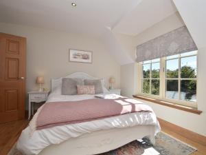 a bedroom with a large bed and a window at 2 Bed in Nr Beadnell 77990 in Ellingham